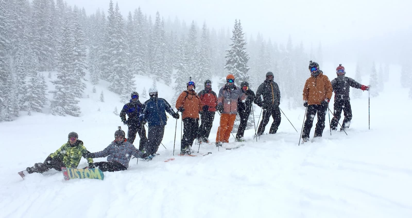 The whole ski crew lined up in deep snowfall on a powder day
