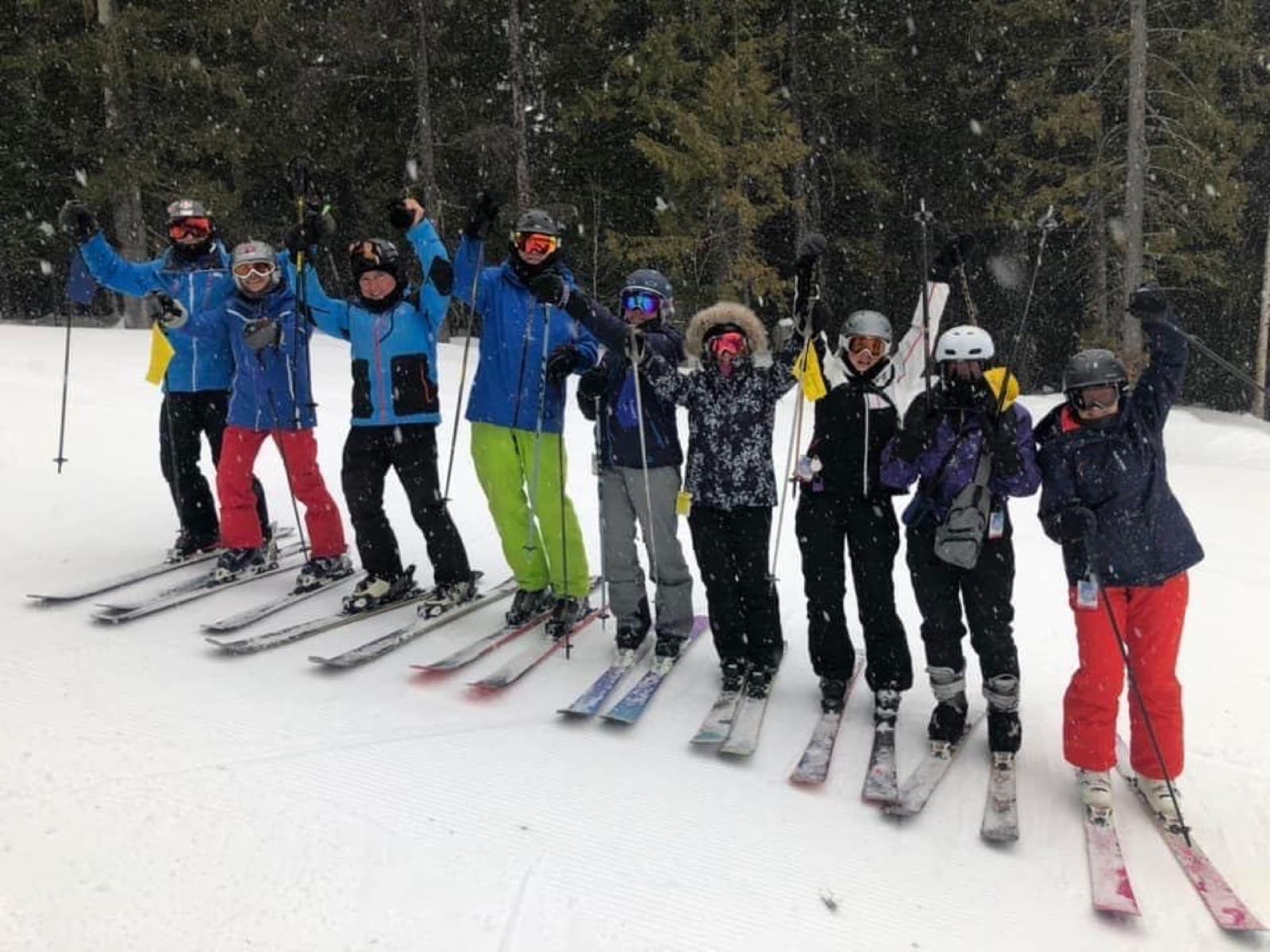 Nine skiers celebrating in falling snow