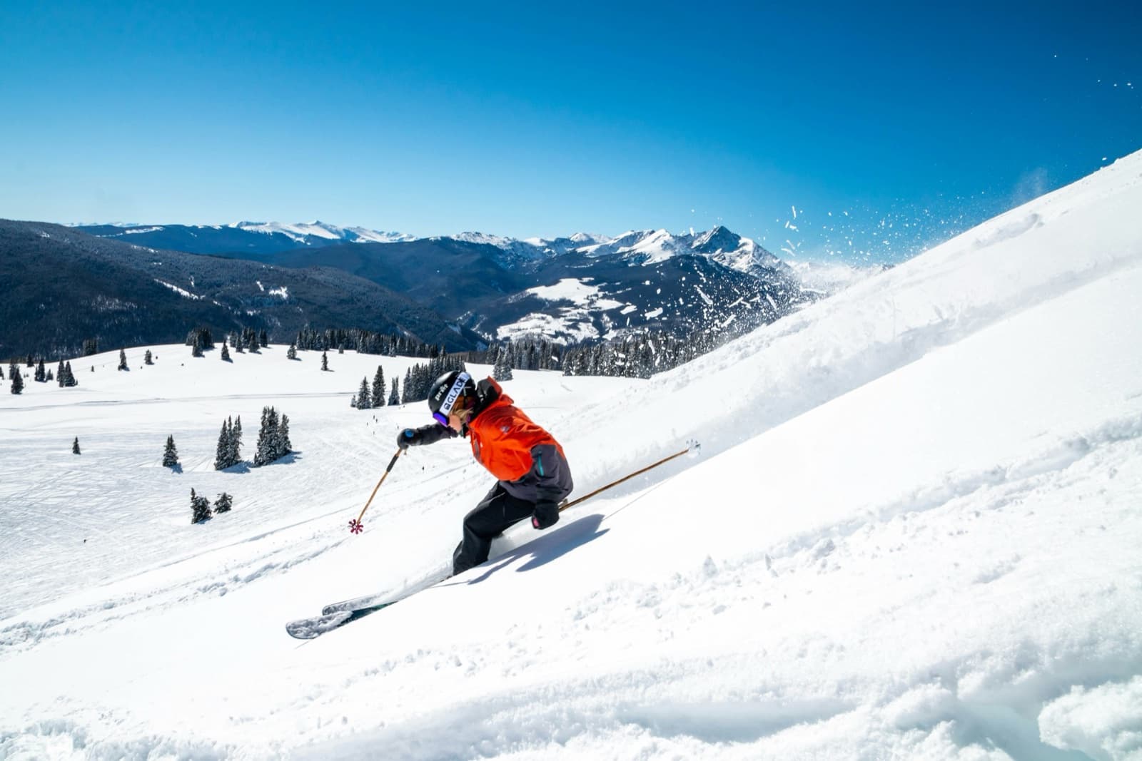 Skier carving a sunlit mountain run