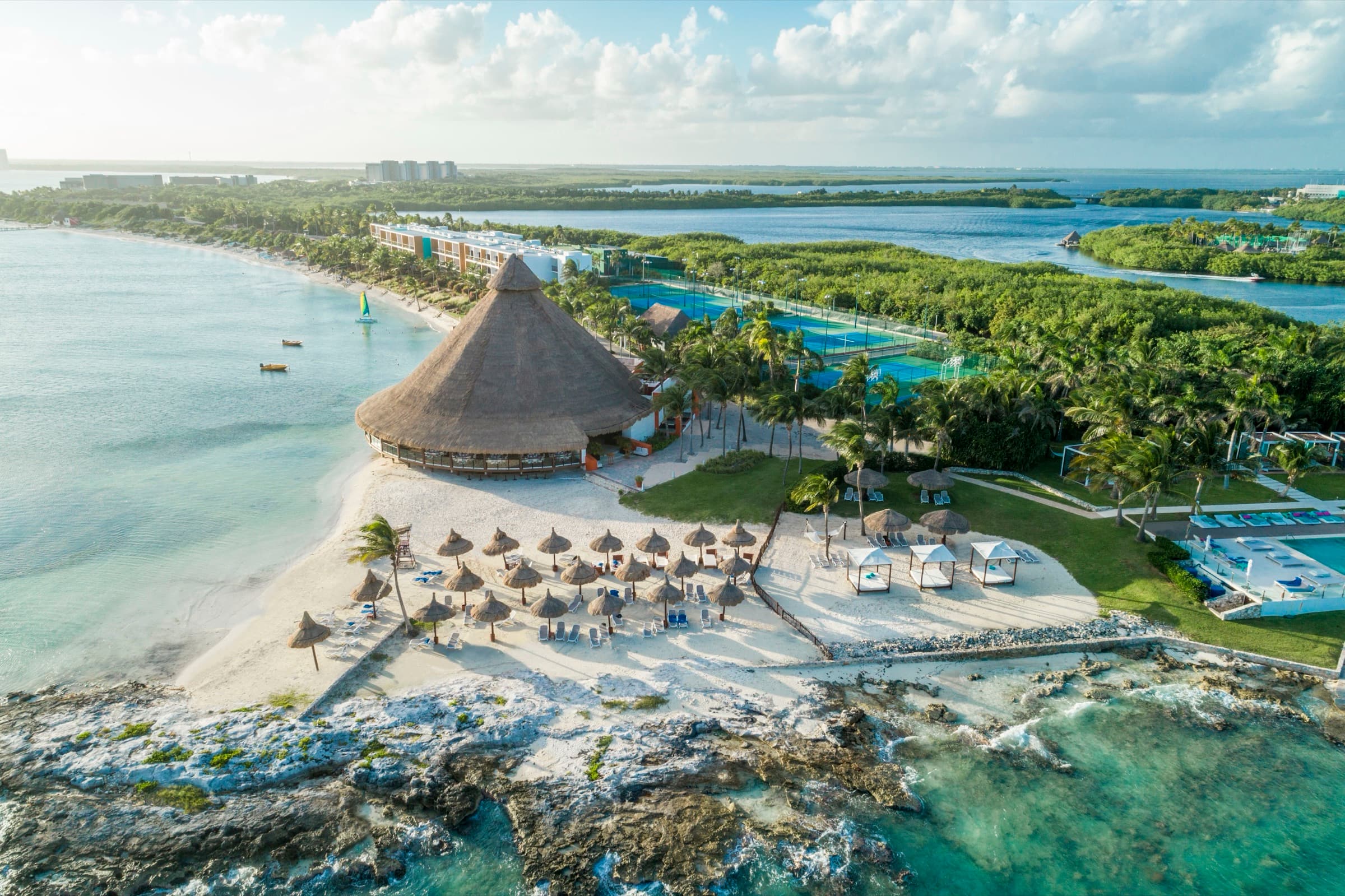 Aerial view of Club Med Cancún Yucatán — a private peninsula with palapa, beaches, and turquoise water on both sides