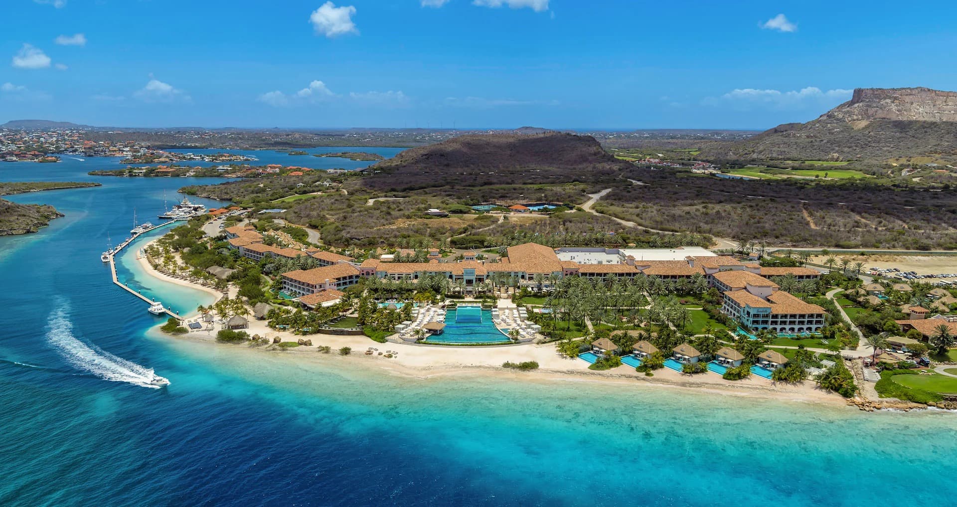 Aerial view of Sandals Royal Curaçao on the Spanish Water bay, with Tafelberg mountain behind and turquoise water in front