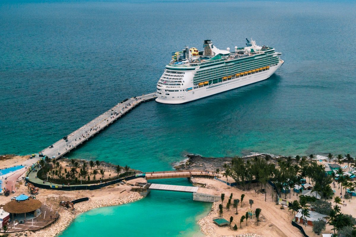Cruise ship docked at a turquoise Caribbean pier, seen from above