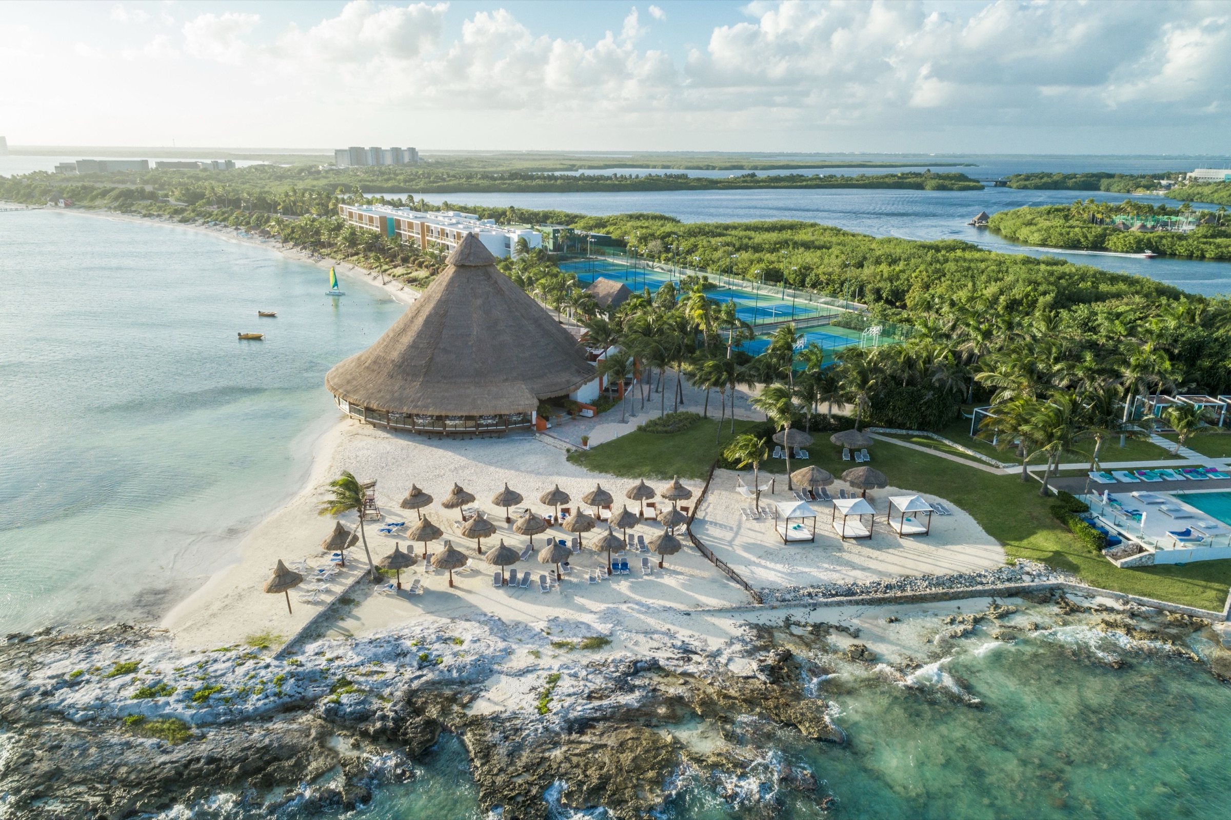 Aerial view of Club Med Cancún Yucatán — a private peninsula with palapa, beaches, and turquoise water on both sides